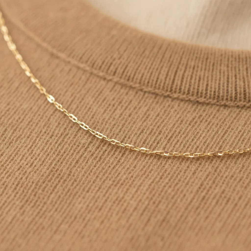 Gold chain necklace on camel cashmere